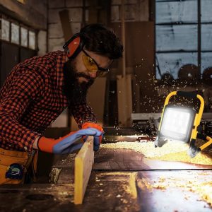 Projecteur De Chantier Qui éclaire Un Homme Qui Travail Dans Une Pièce Sombre