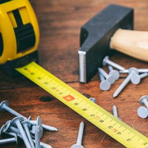 Sur Cette Image On Voit Un Mètre Pour Mesurer Et Un Marteau Avec Un Petite Tas De Pointes